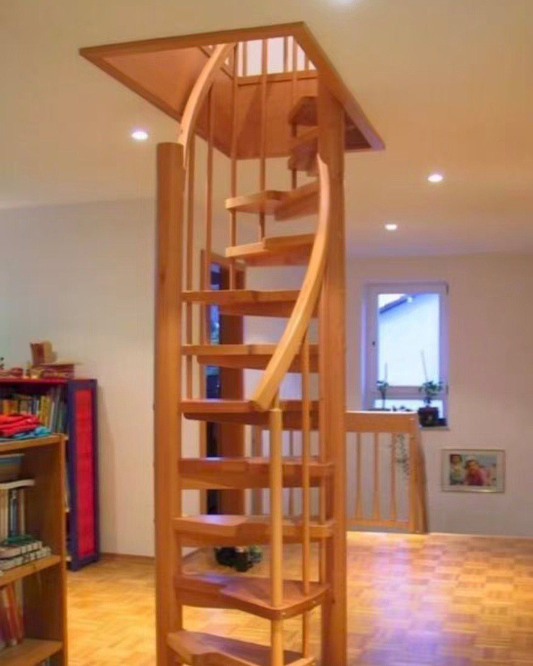 Wooden spiral staircase leading to an upper floor in a bright modern room.