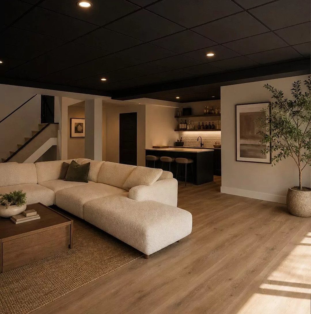 Black drop ceiling with recessed lights in a modern basement living room