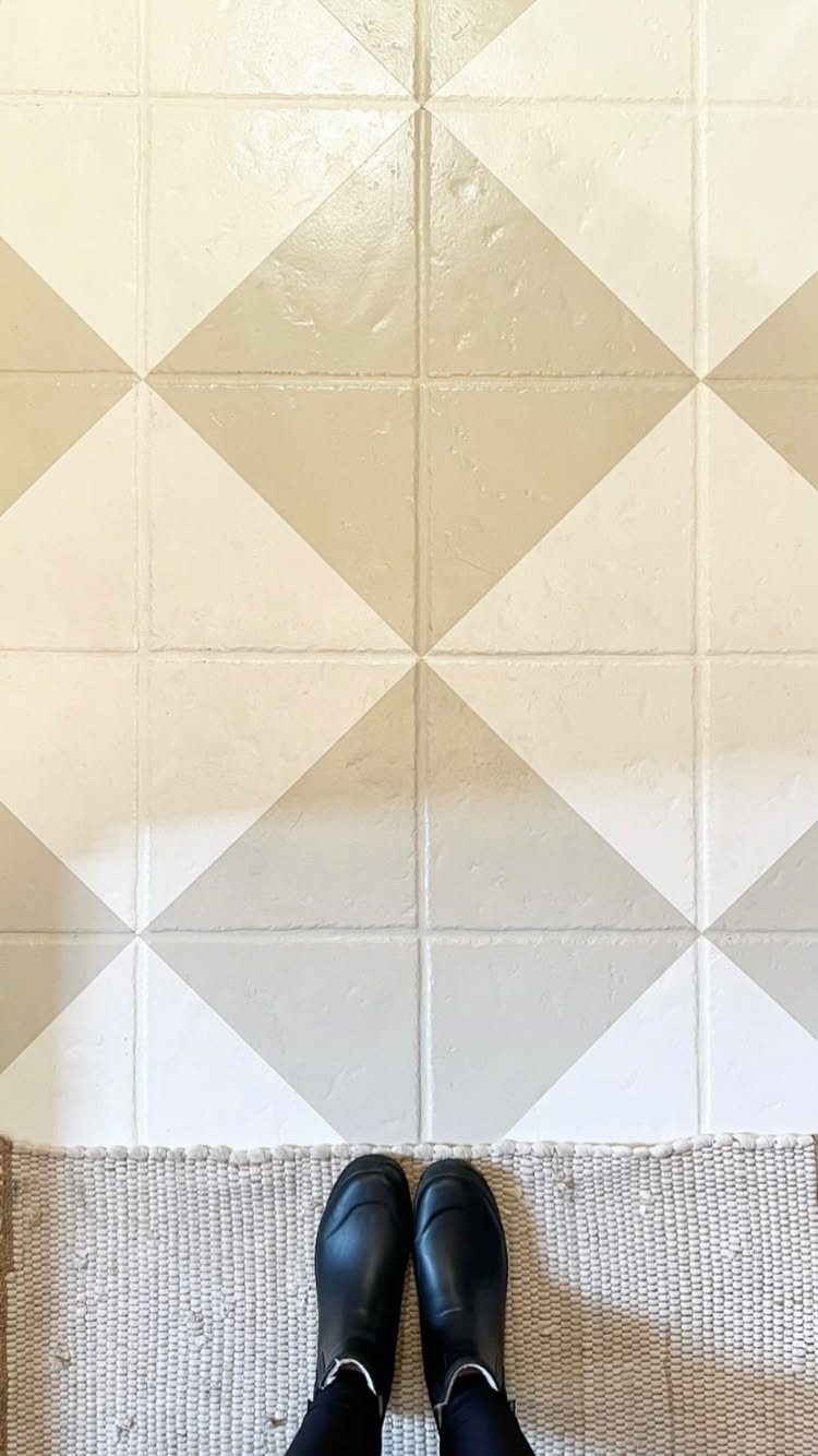 Painted geometric diamond pattern floor in white and beige with black boots nearby