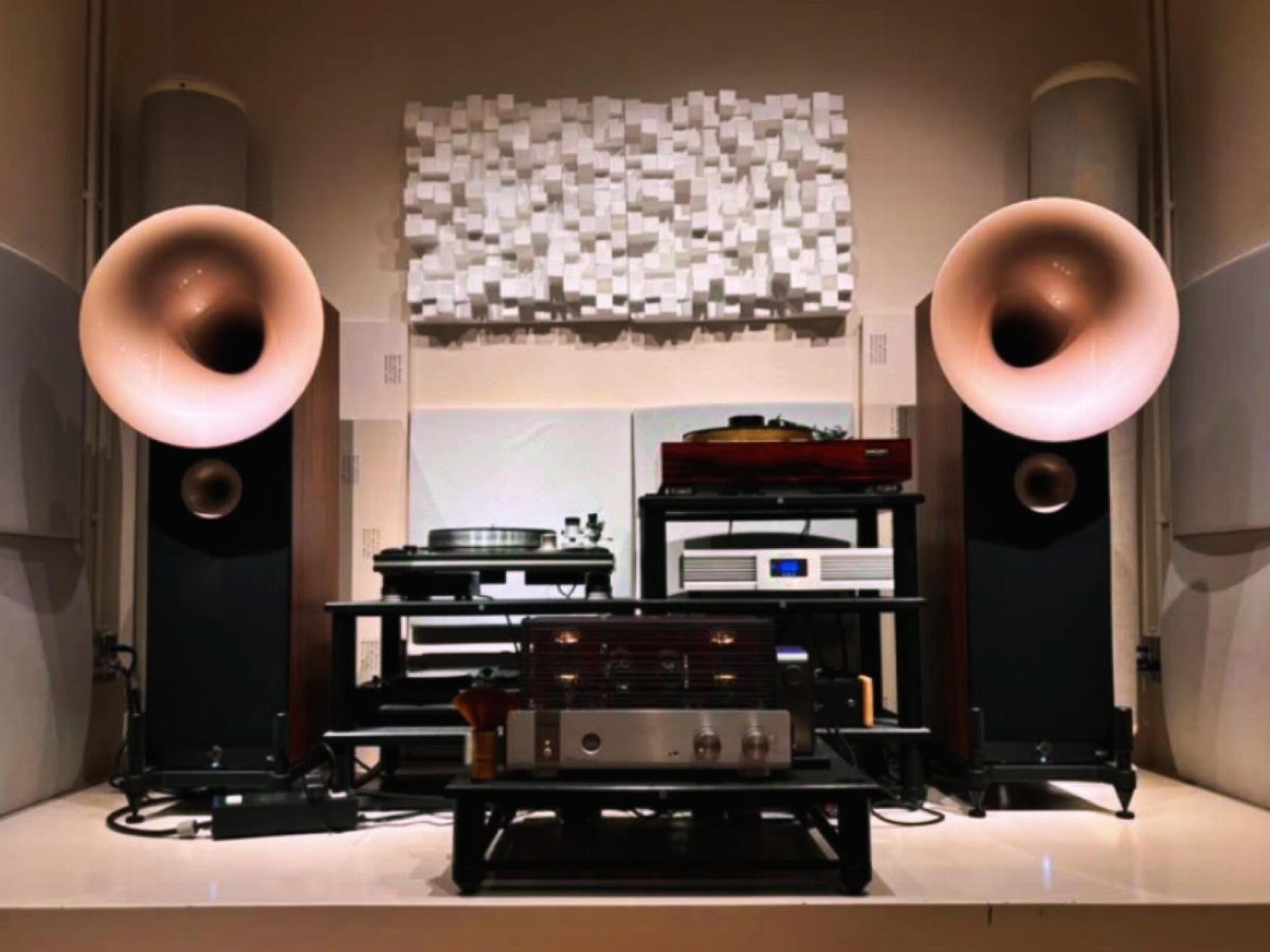 High-end sound system with large horn speakers and acoustic wall panels in a room