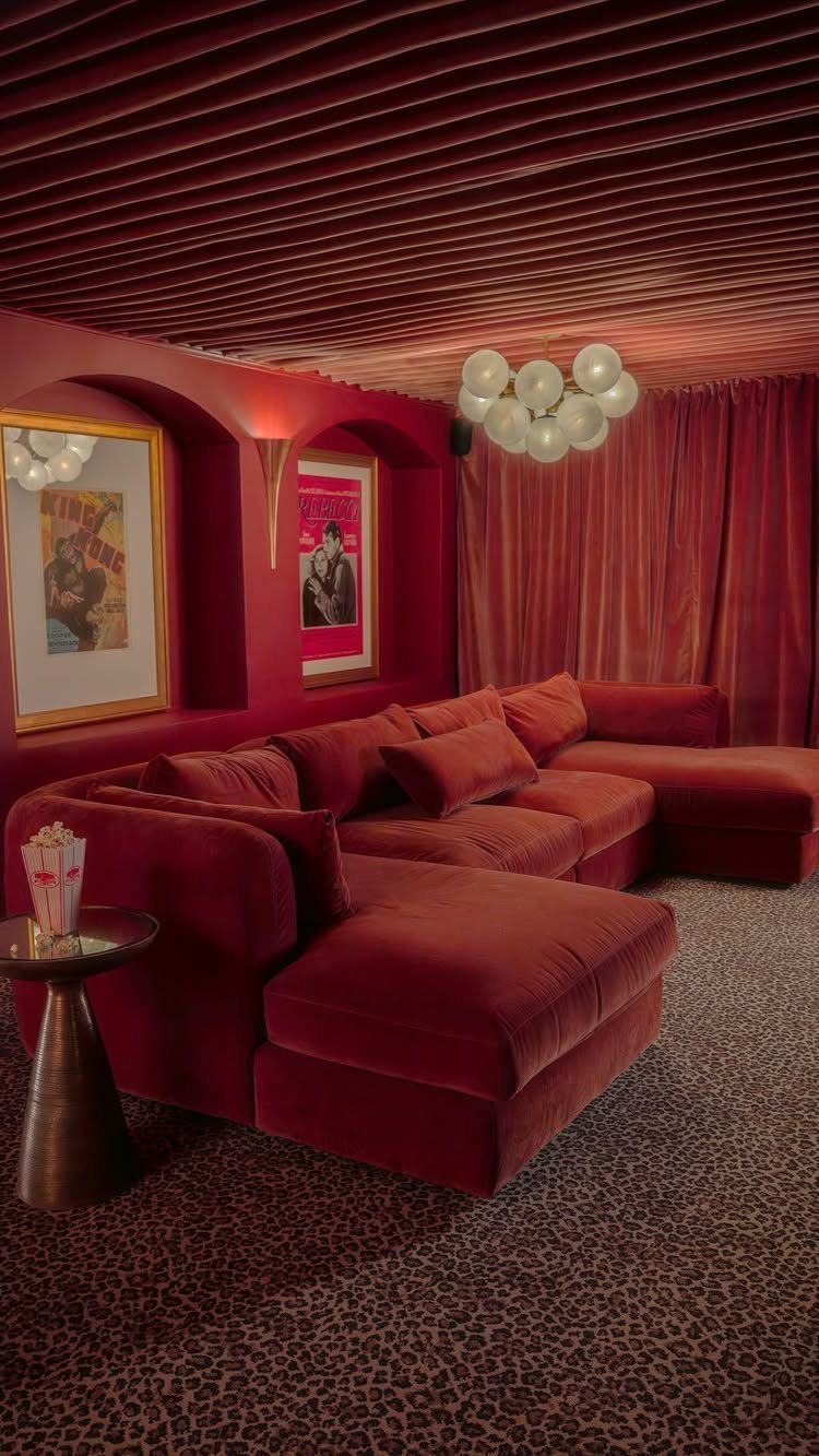 Red velvet sectional sofa in a themed home theater with leopard-print carpeting.