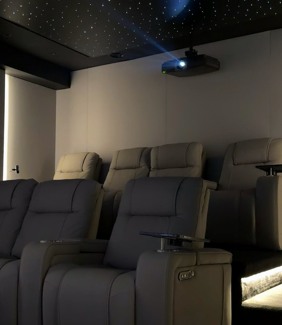Home theater with grey leather recliners and a starry night fiber optic ceiling.