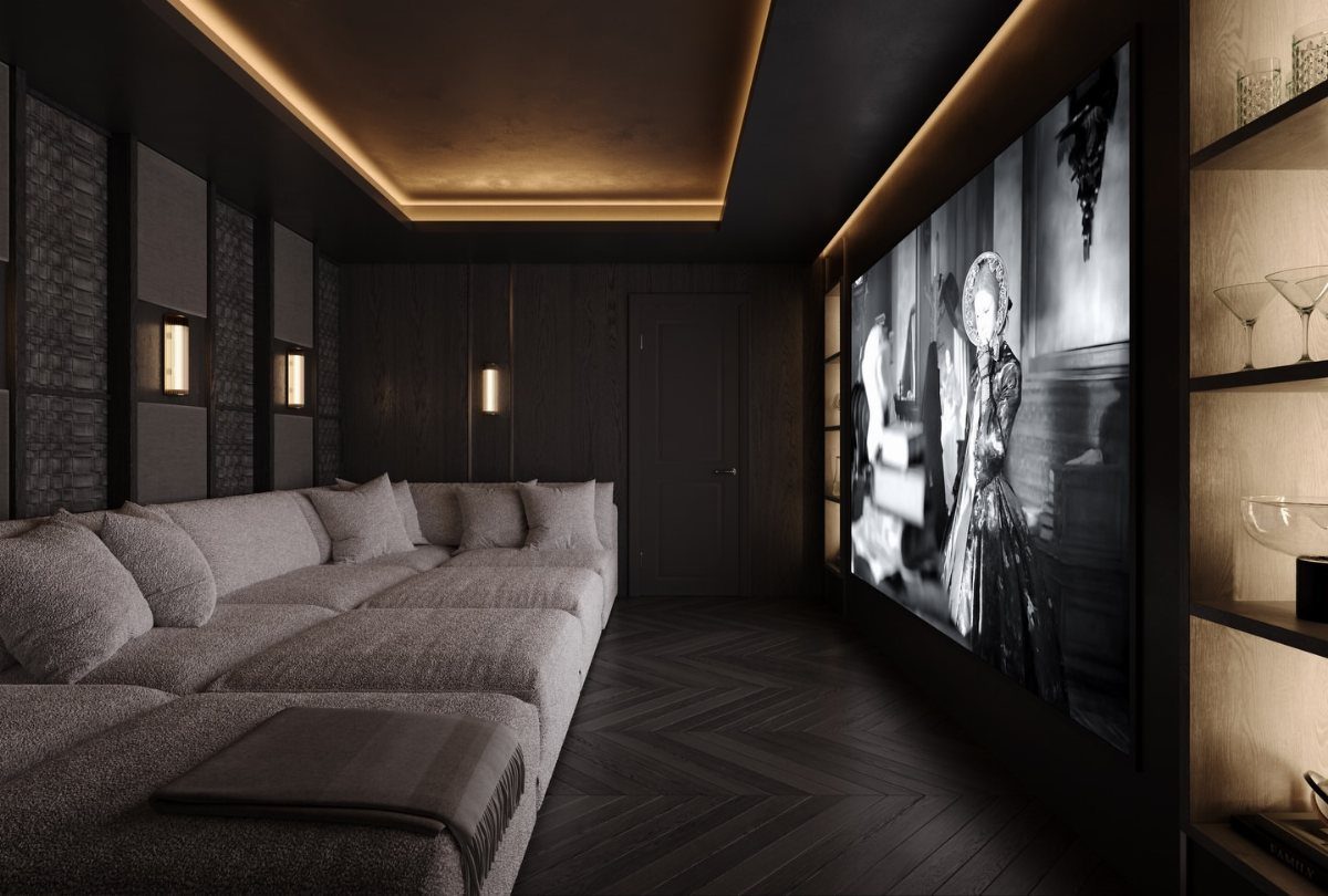 Large grey sectional sofa in a dark home theater with a movie screen.