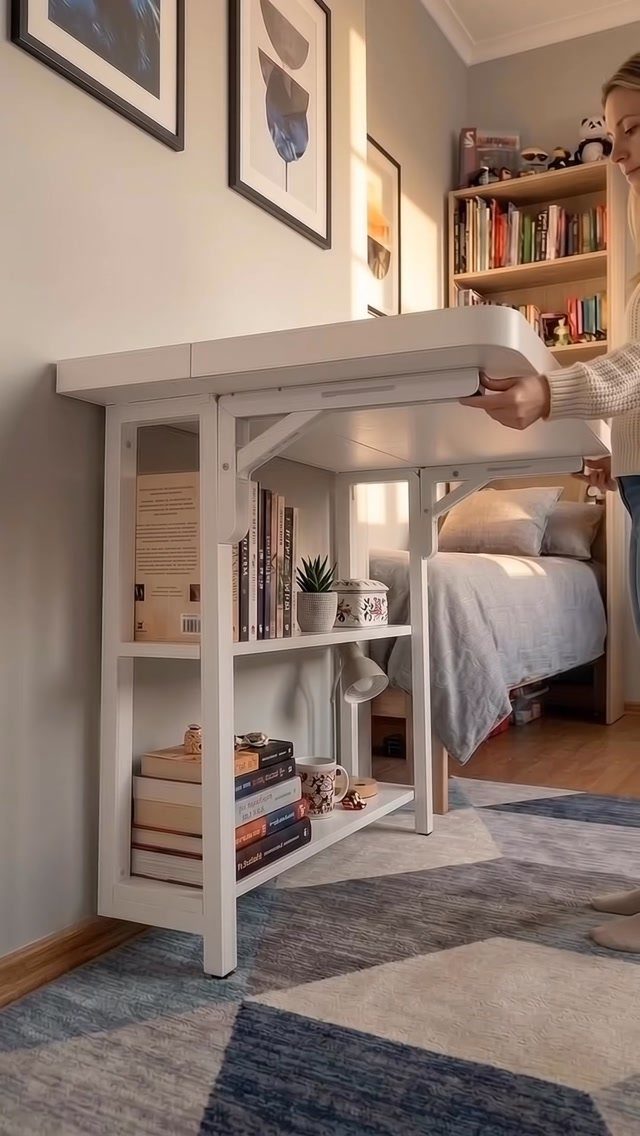 White fold-down wall desk with shelves next to a bed in a bedroom
