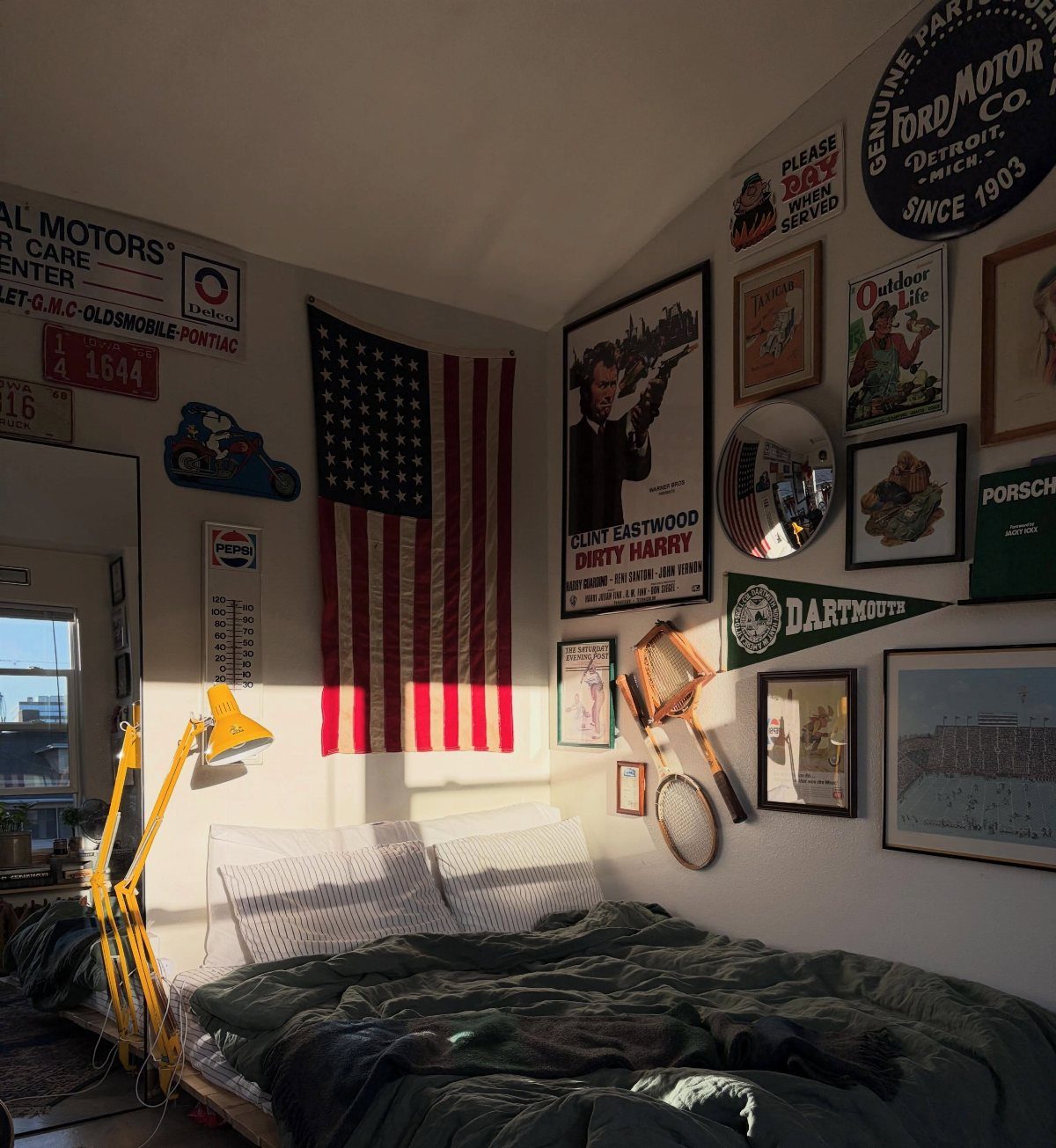 Bedroom with sloped ceilings decorated with vintage signs, posters, and a US flag.