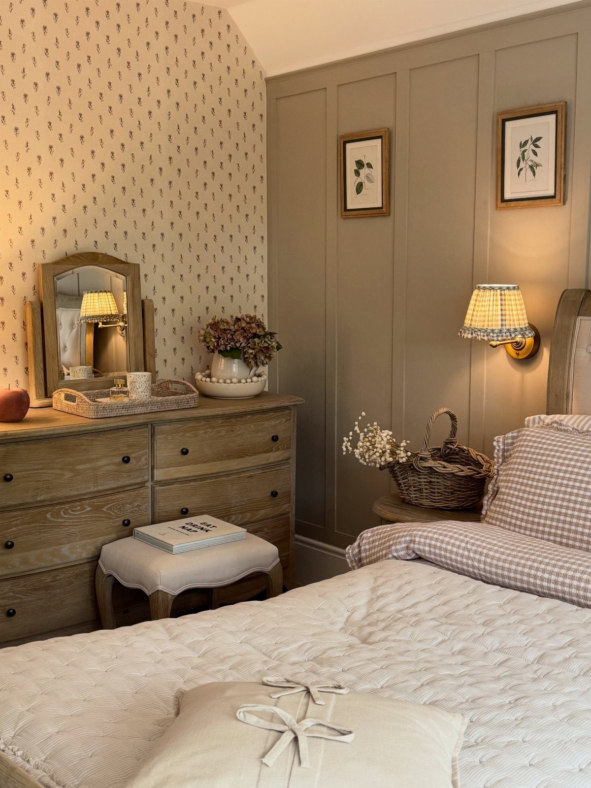 Wooden dresser and bed with checkered textiles in a cozy, neutral-toned bedroom.