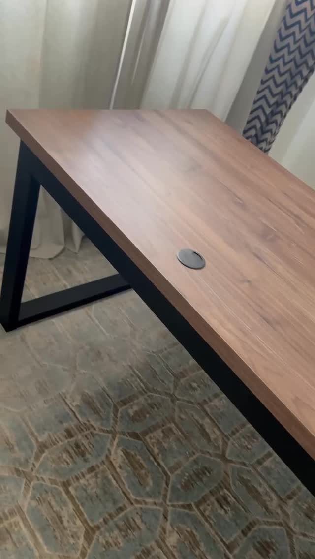 Wooden butcher block desk with black legs and a circular cable grommet hole.