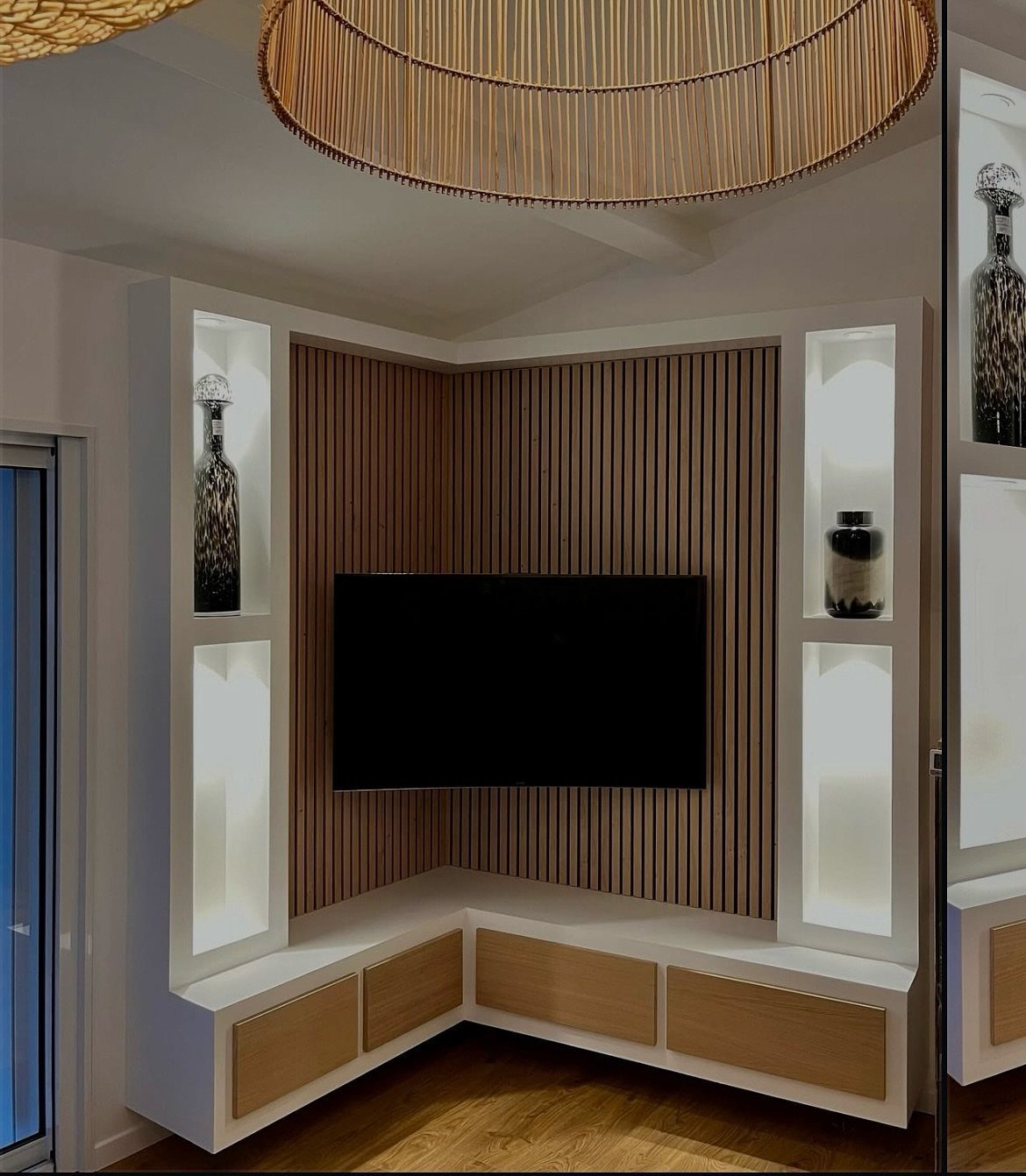 TV mounted in a room corner with wood-slat walls and white built-in shelving