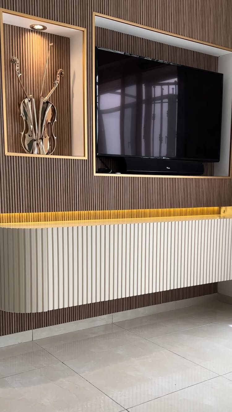 Flat-screen TV in a recessed wall niche with a floating white ribbed cabinet.