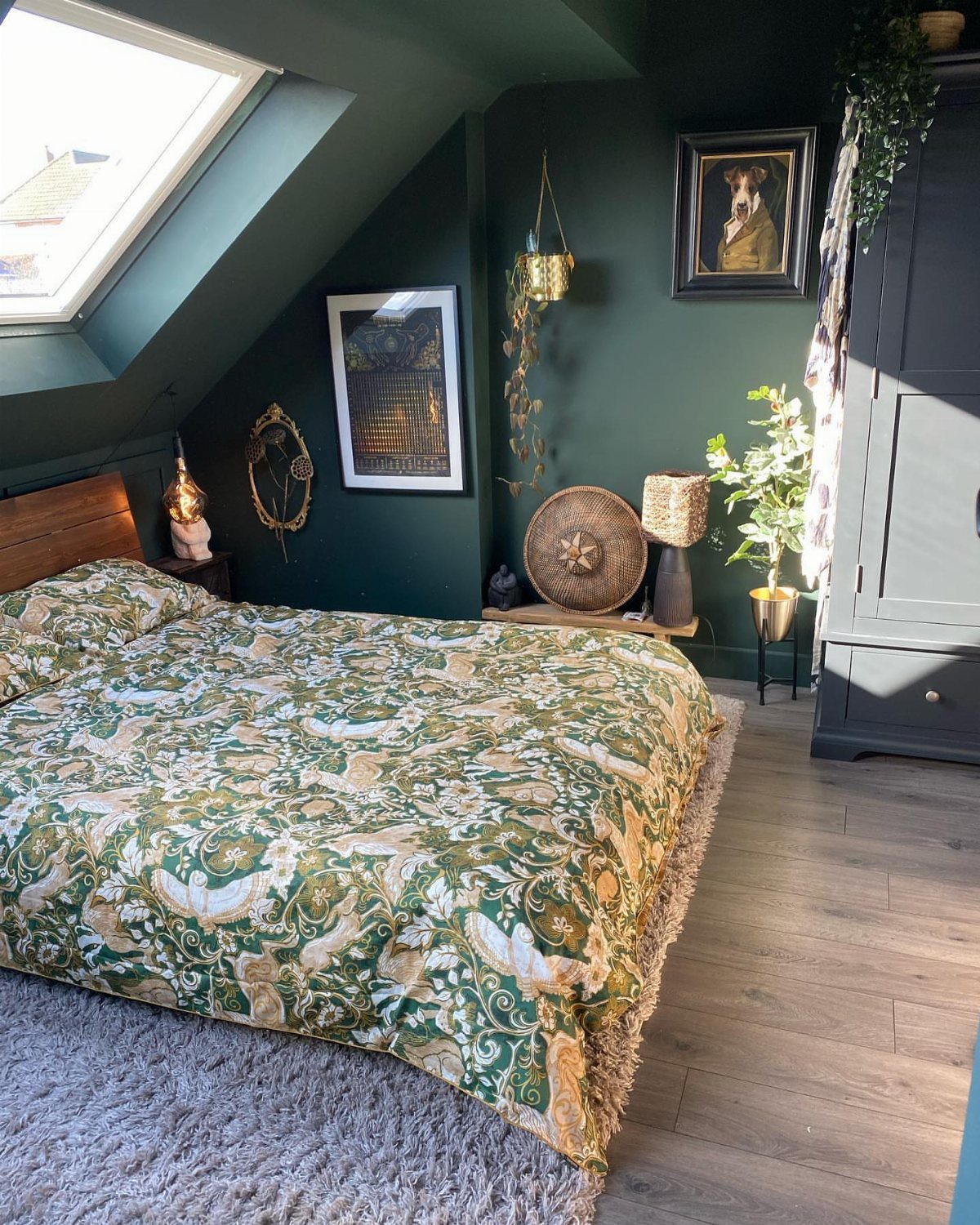 Bedroom in a finished attic with dark green walls and a skylight window.