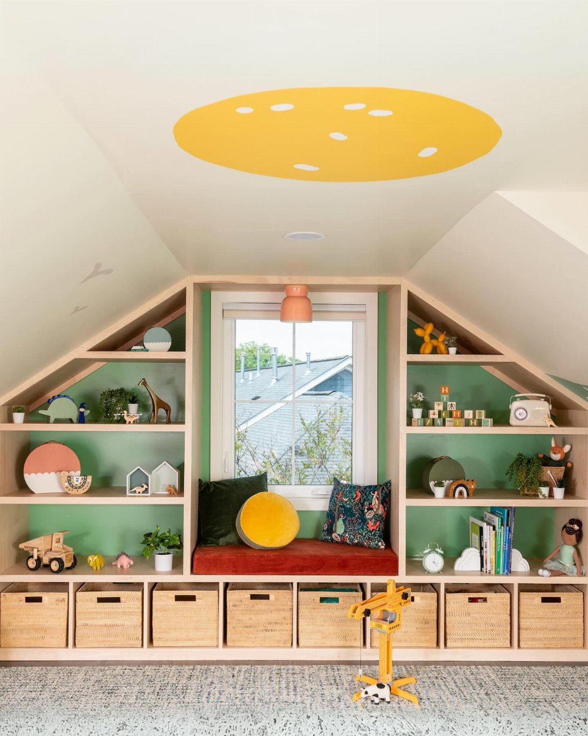 Finished attic room with built-in wooden shelves, window seat, and yellow ceiling mural.