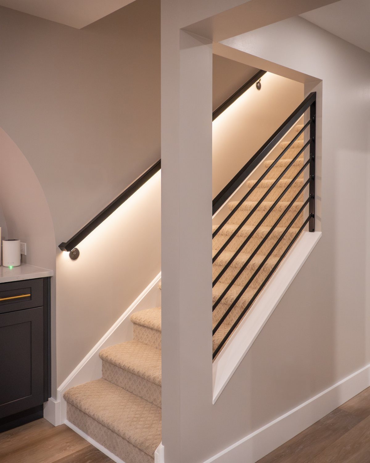 Modern staircase with beige carpet and integrated LED strip lighting along the wall