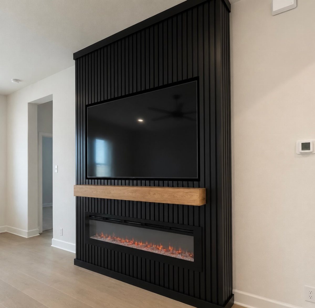 Floating wooden mantel shelf separating a flat-screen TV from a linear electric fireplace.