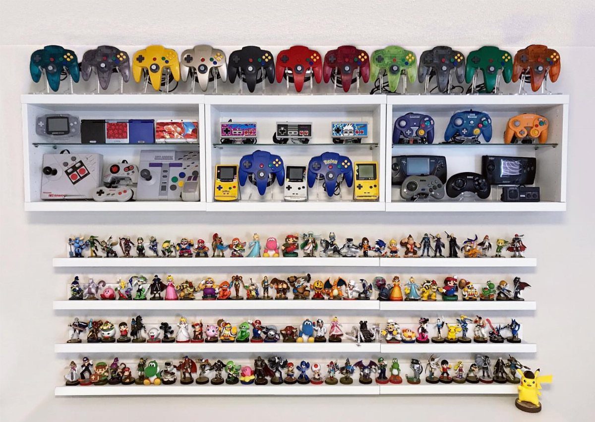 White wall-mounted shelves displaying colorful gaming controllers and a large collection of figurines.