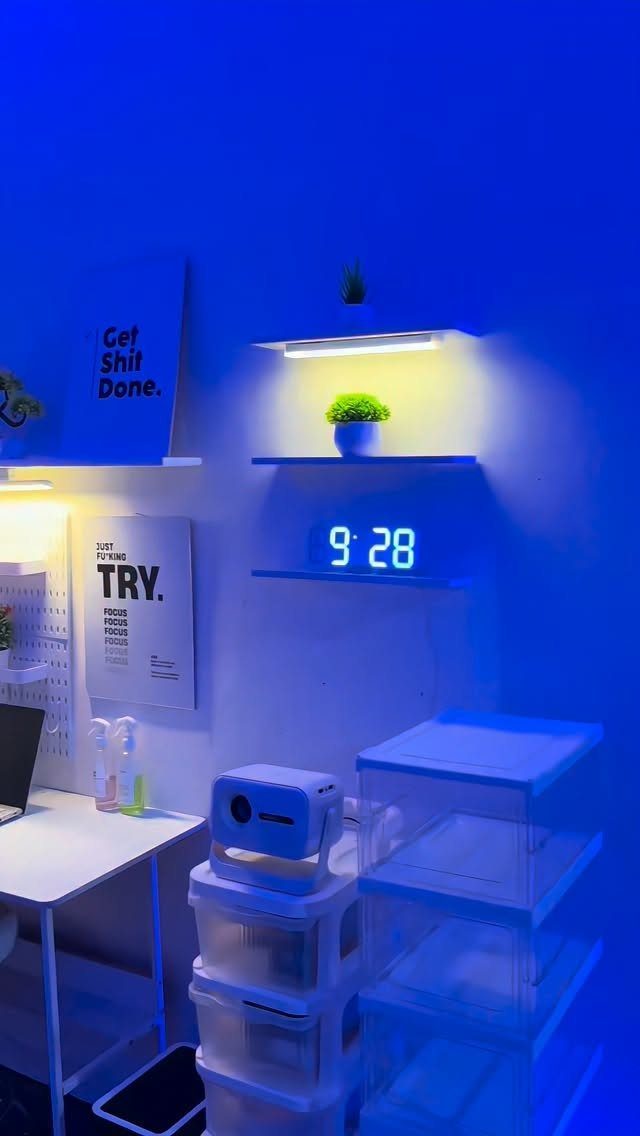 White floating shelves with a digital clock and plant in a blue-lit room.