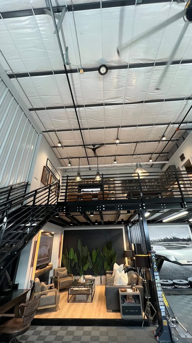 Modern industrial garage conversion with a living room area and a black metal mezzanine.