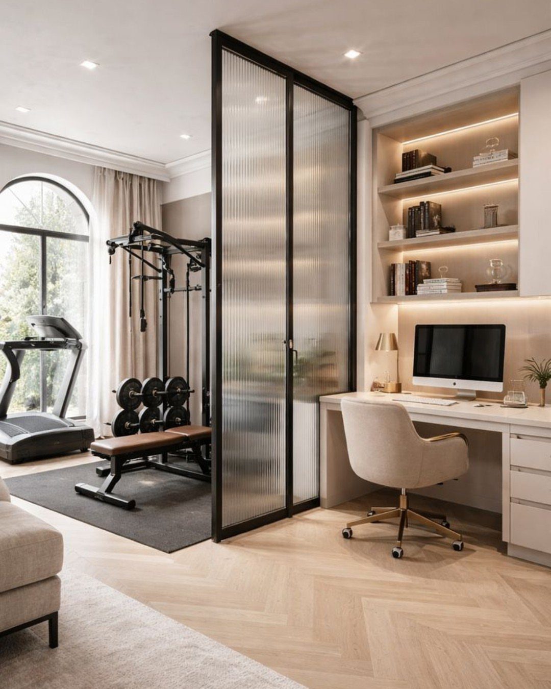 Modern room divided by glass partition featuring a home gym and home office.