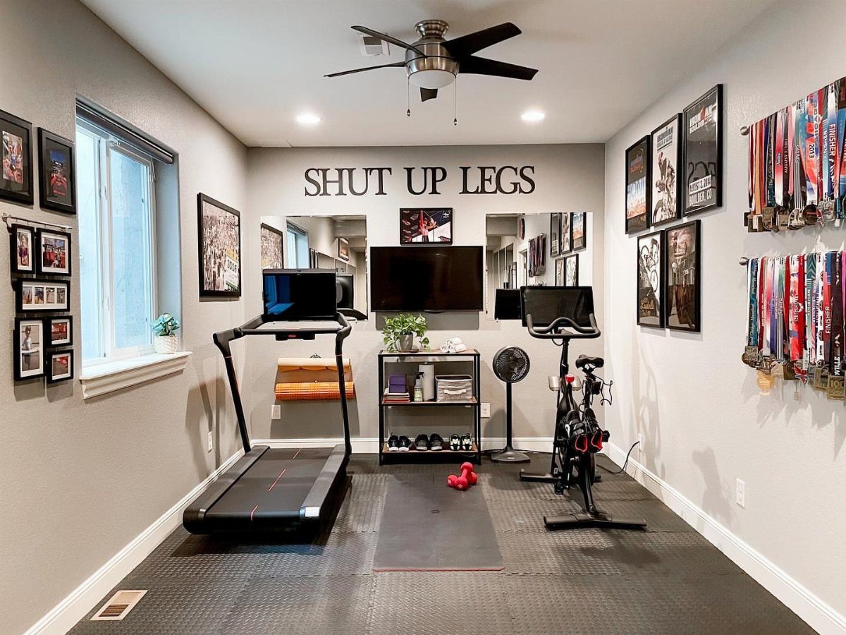 Black textured rubber mats covering the floor of a home gym setup.