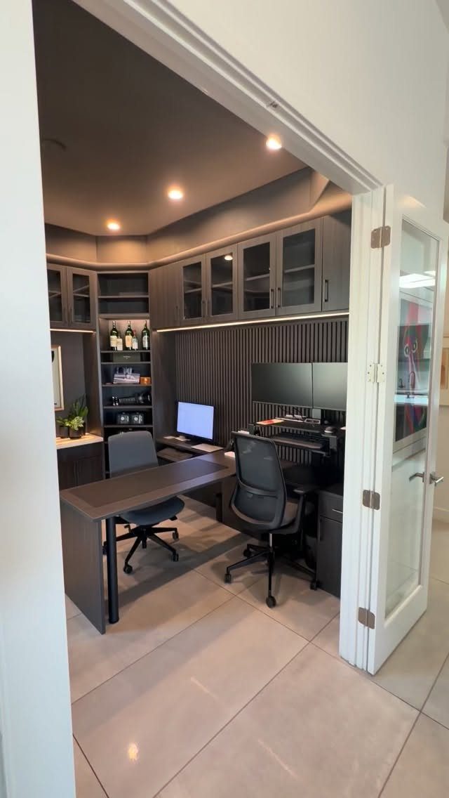Dark grey built-in office cabinetry and L-shaped desk in a modern home workspace