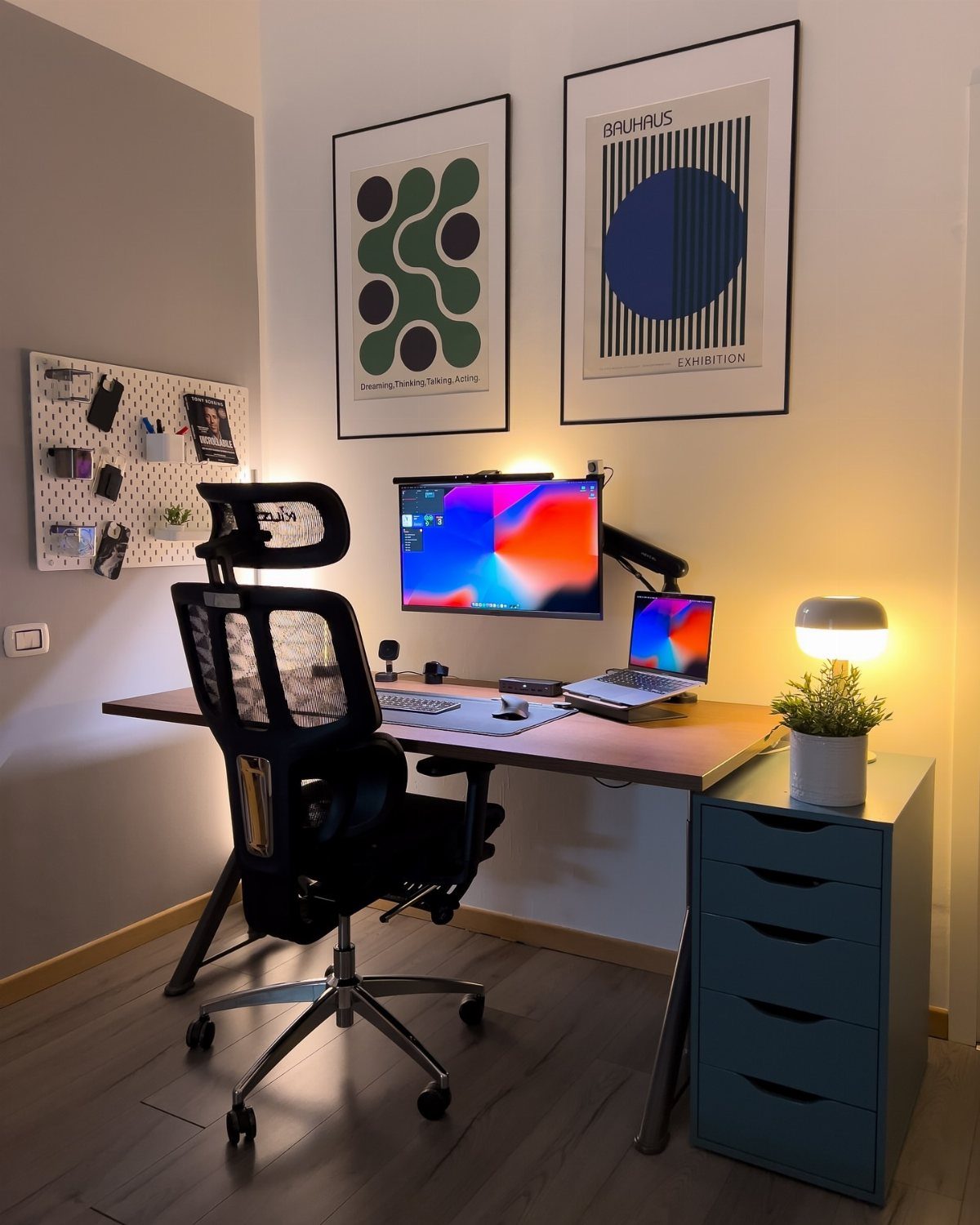 Modern home office desk setup with ergonomic chair, dual screens, and minimalist decor.