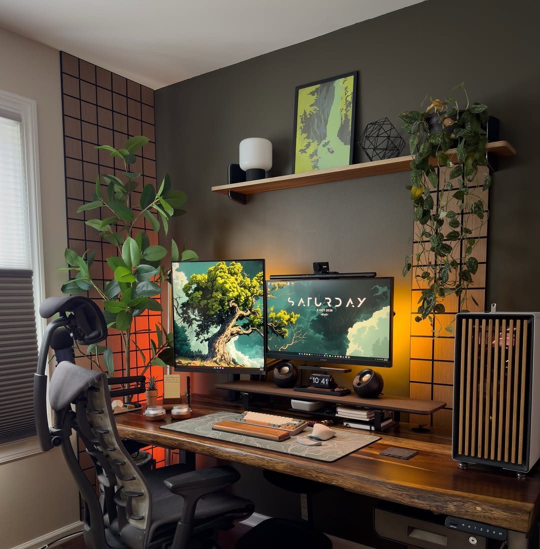 Wooden desk with a grey desk pad, dual monitors, and an ergonomic chair.