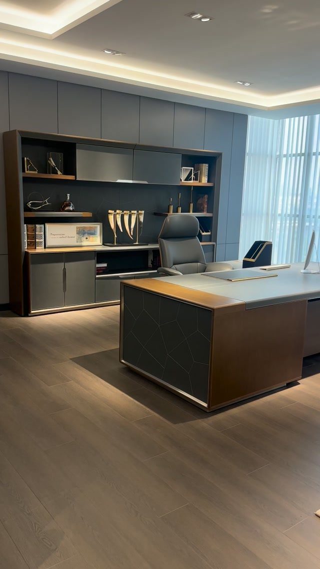Modern executive home office with a large desk, leather chair, and wall shelving.