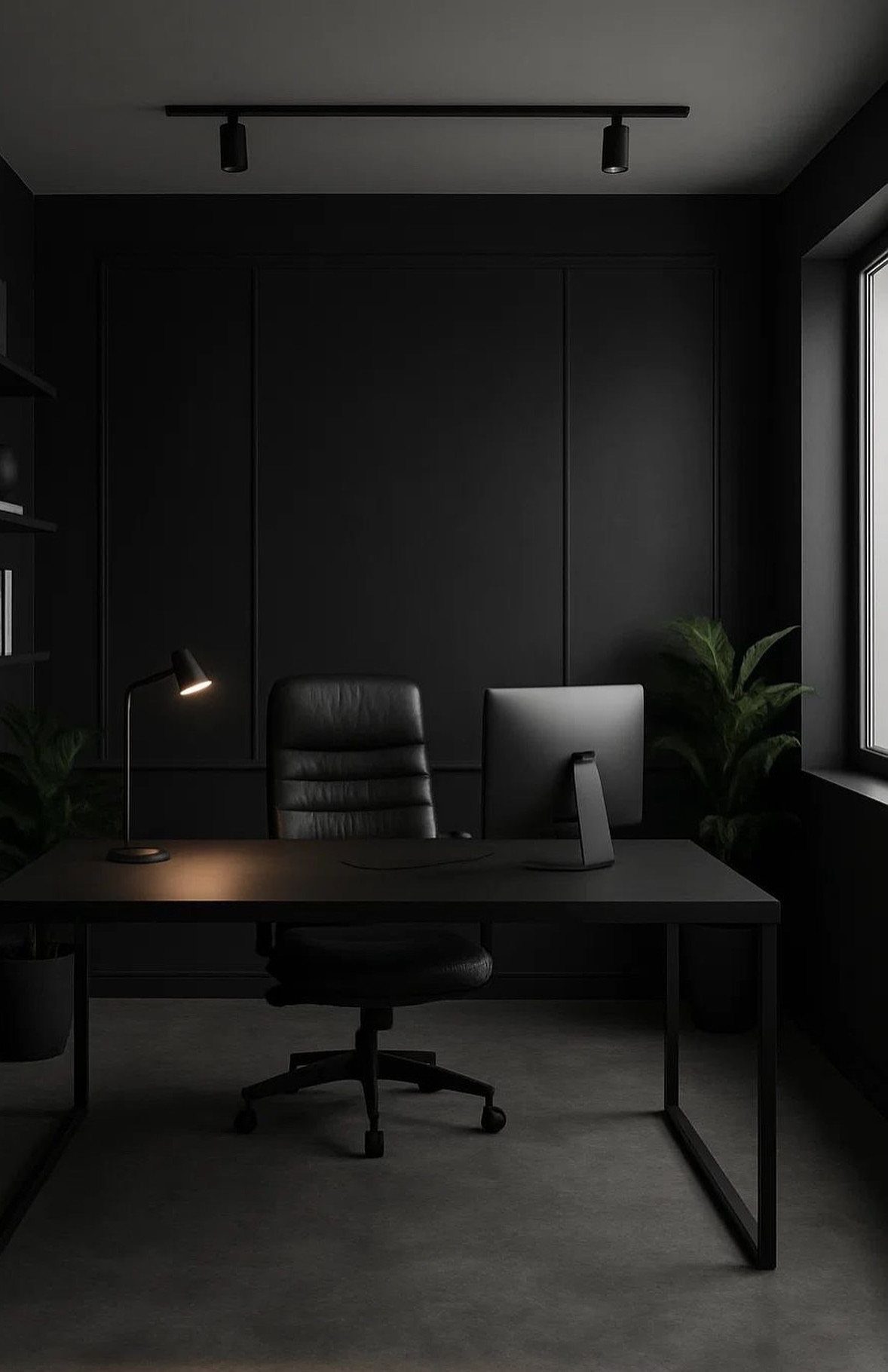 Black desk and leather chair in a dark, moody home office with paneled walls.