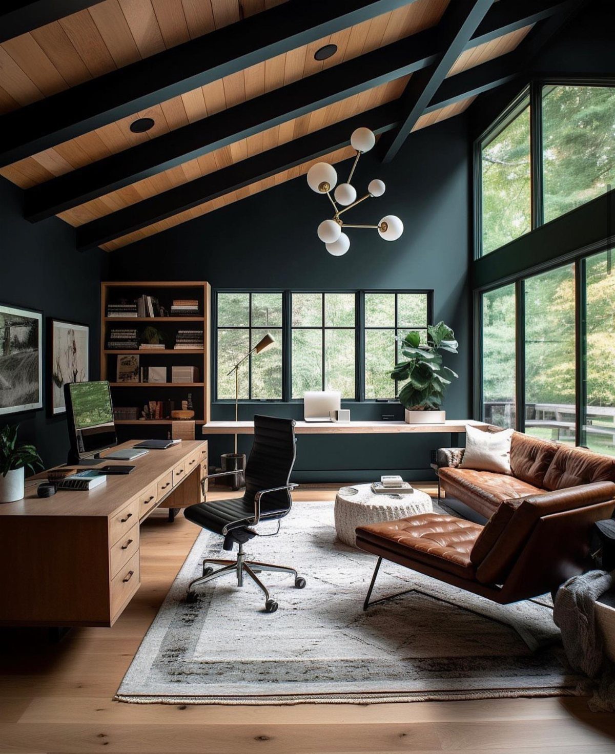 Modern home office with dark green walls, wooden desk, and brown leather sofa.