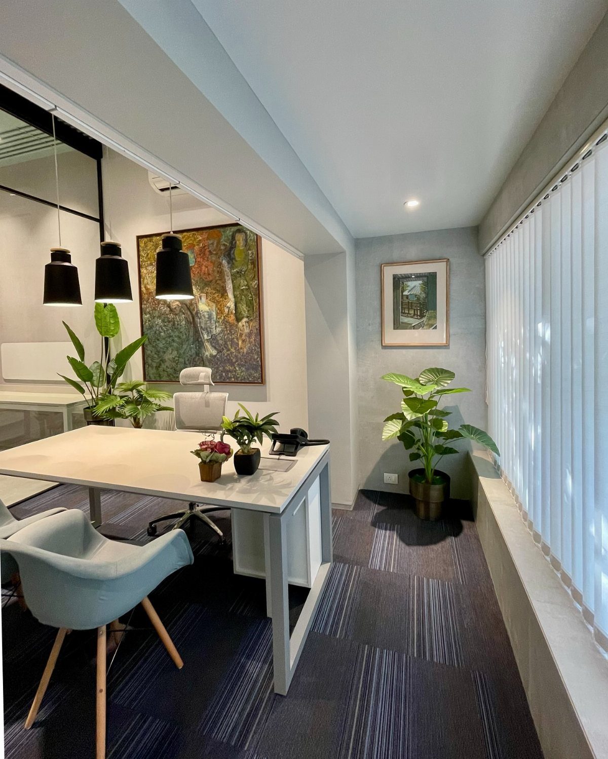 Modern home office with a white desk and bright natural light from a window.