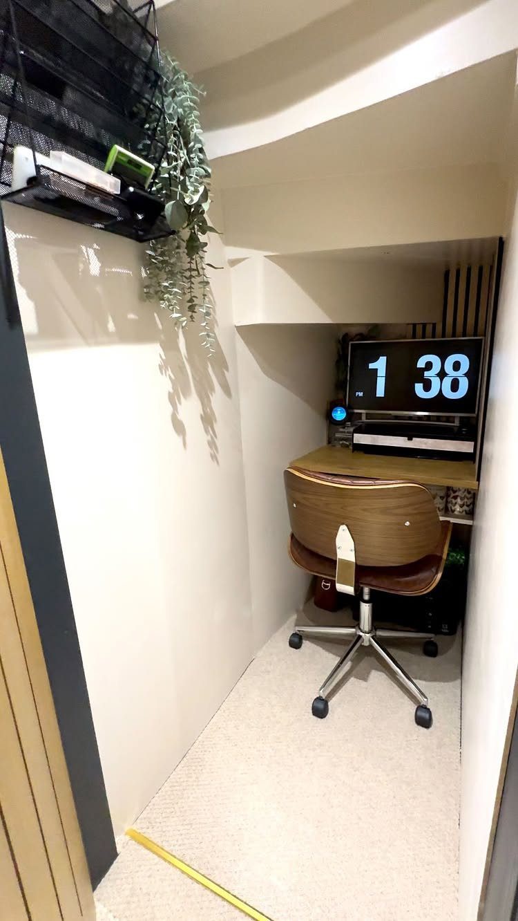 Small home office setup in a narrow alcove with wooden desk and chair