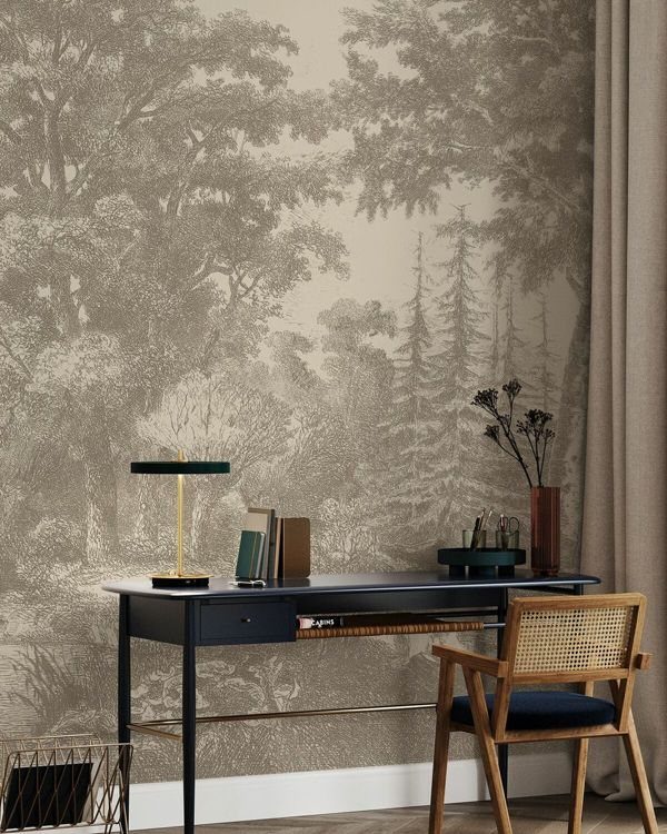 Dark blue desk and cane chair against a sepia forest mural wall.
