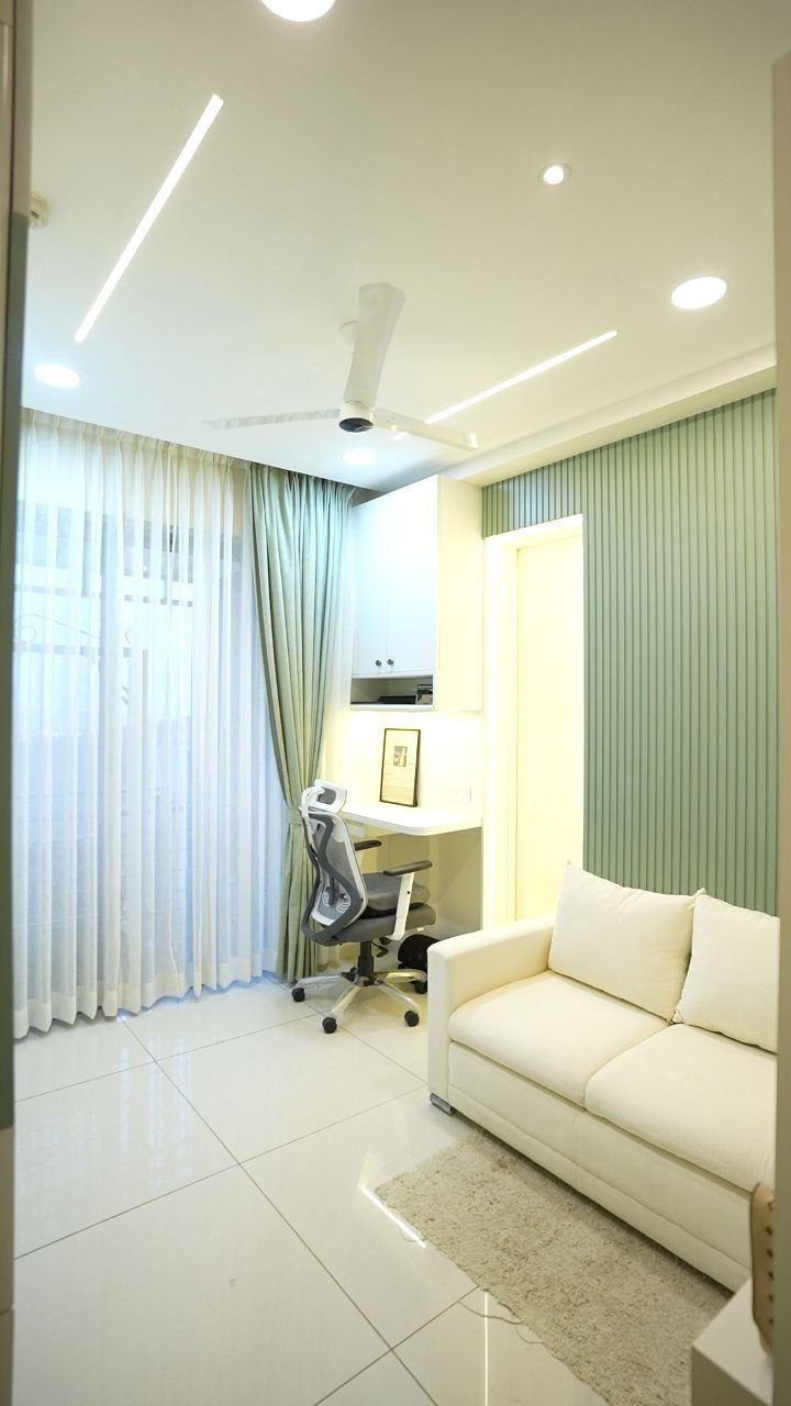 Small home office area with a desk, chair, and white sofa in a room.