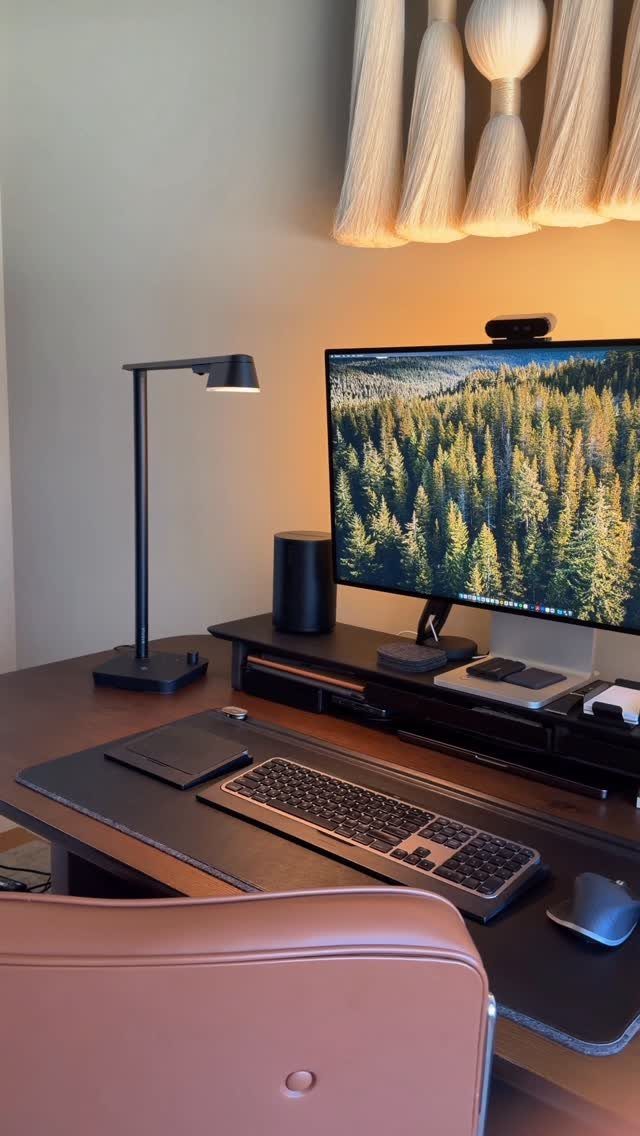 Modern home office desk with monitor, keyboard, mouse, and black desk lamp.
