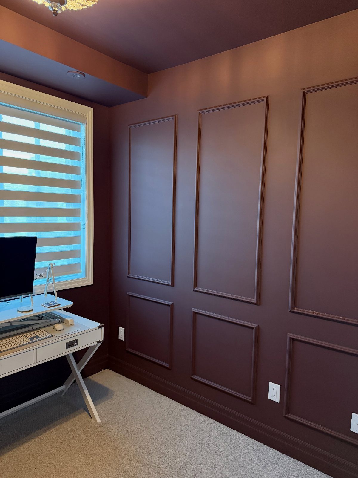 Burgundy painted home office walls with decorative molding and a white desk