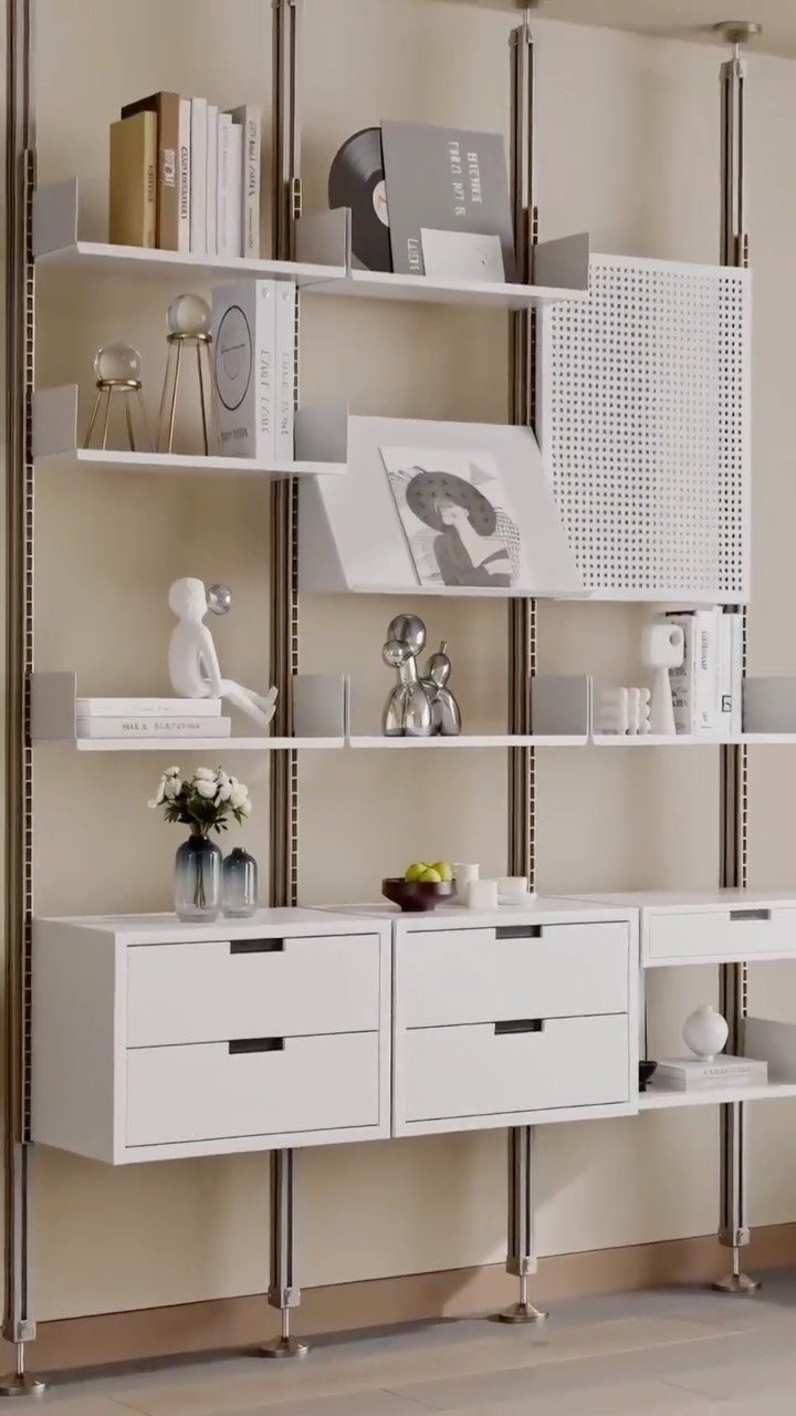 White modular shelving system with drawers and open shelves holding books and decor.