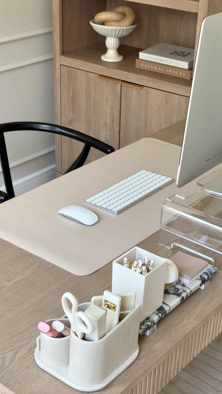 Tidy wooden desk with computer, beige desk mat, and white stationery organizer.