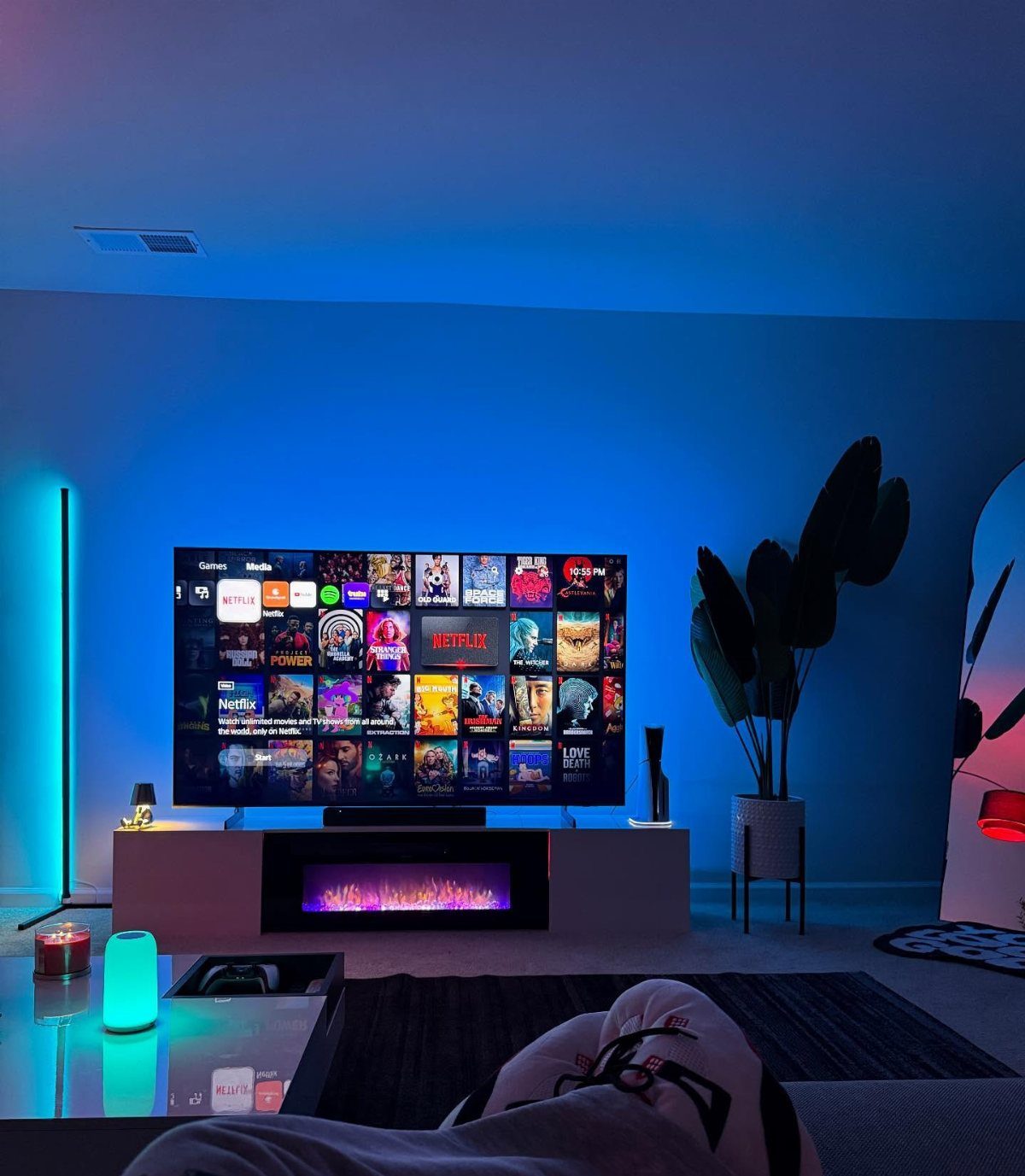Large flat-screen TV with streaming menu and blue ambient LED lighting in room