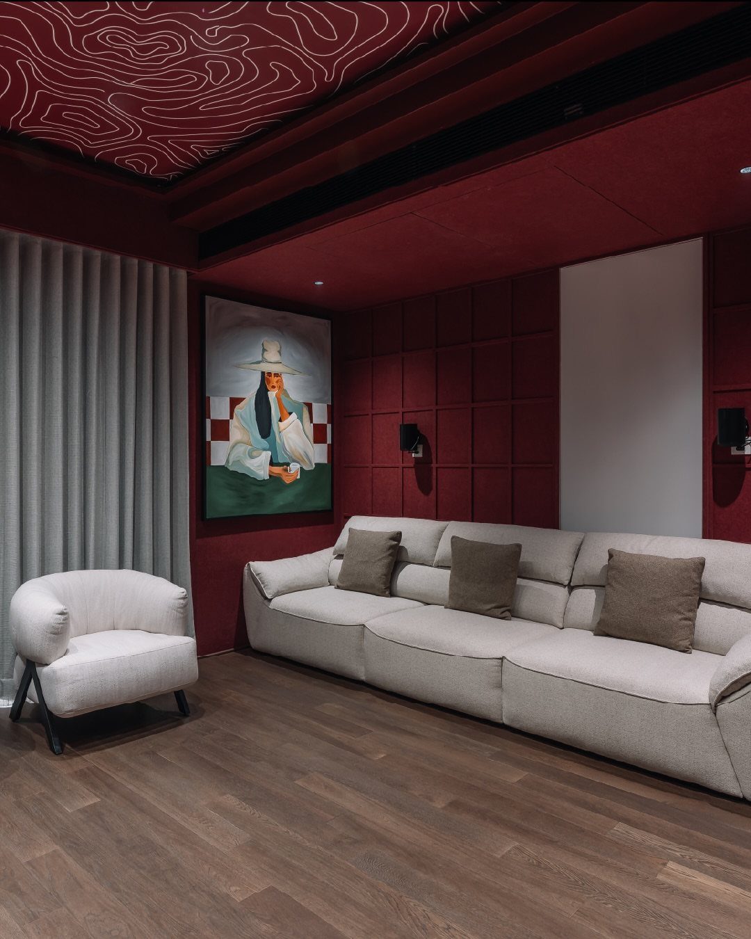 Dark burgundy walls and ceiling in a modern room with a grey sofa.