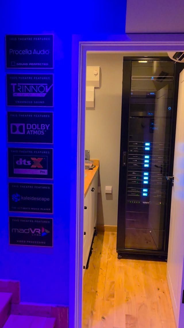 Equipment rack with audio components inside a room with blue ambient lighting.