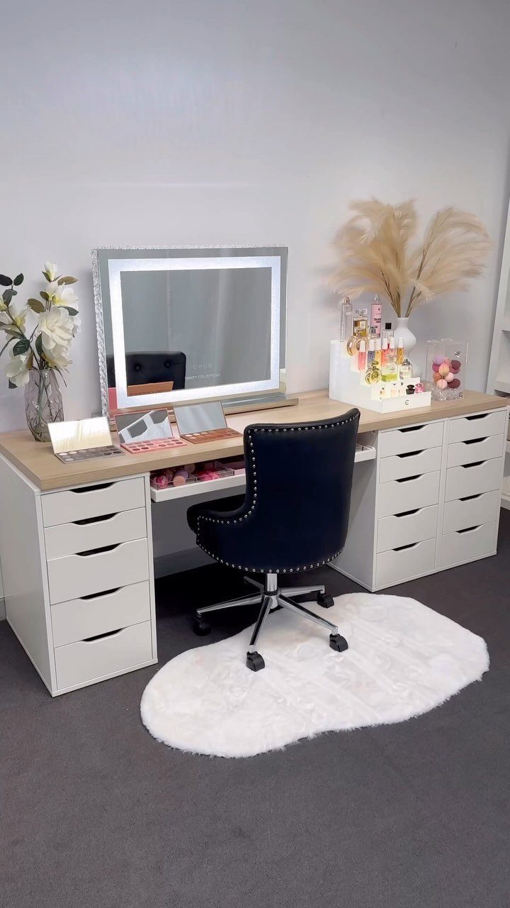 White IKEA Alex drawer desk with wood top, mirror, and black office chair.