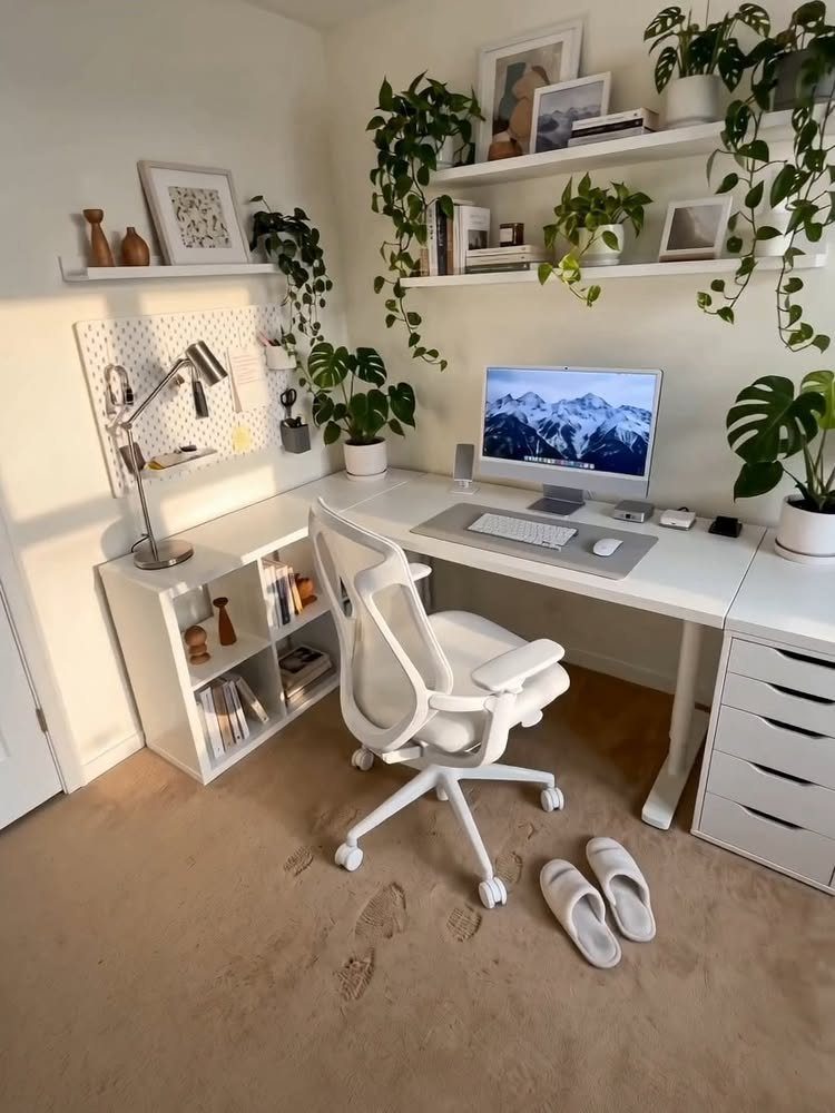 White desk with IKEA Alex drawers, white chair, and potted plants in office.