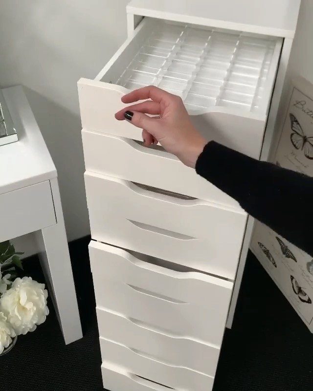 White IKEA ALEX drawer unit with a plastic grid organizer inside the top drawer.