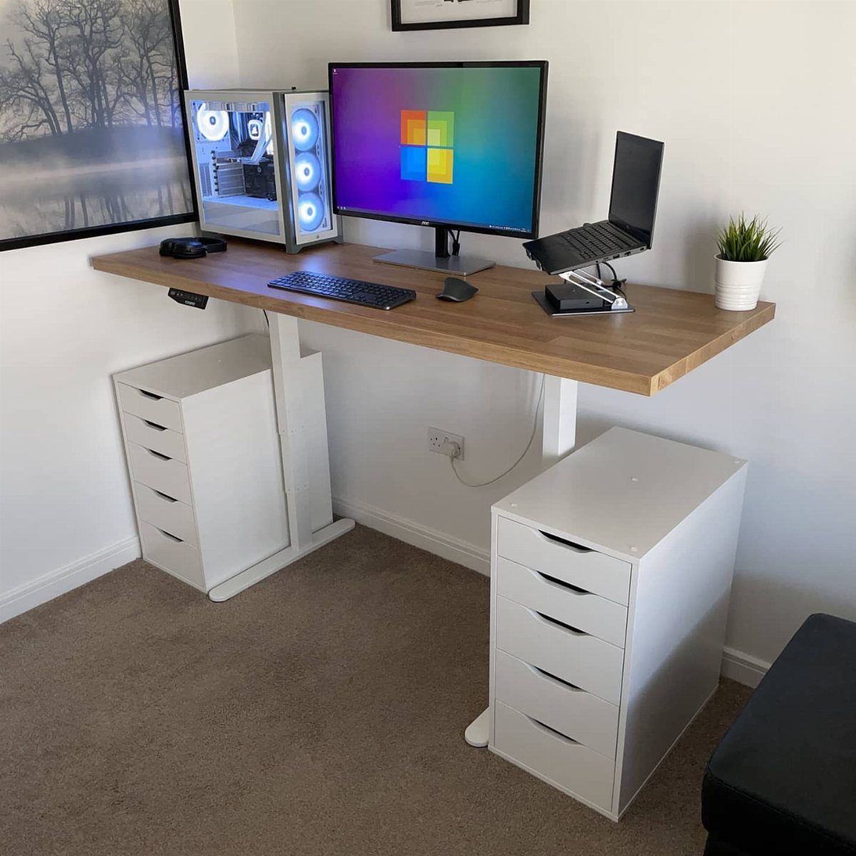 Wooden desk supported by white Alex drawer units with a gaming PC setup.
