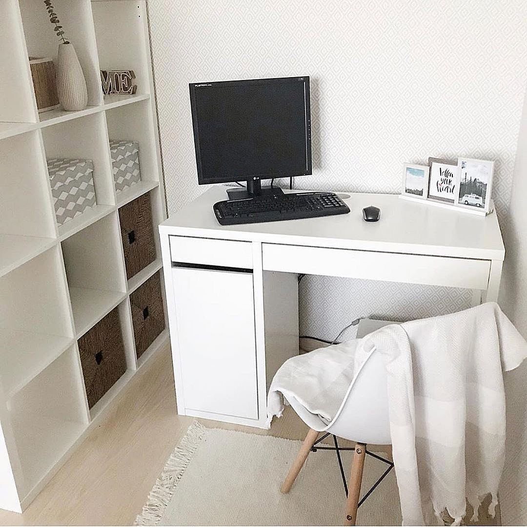 White modern desk with computer monitor next to white cube shelving unit
