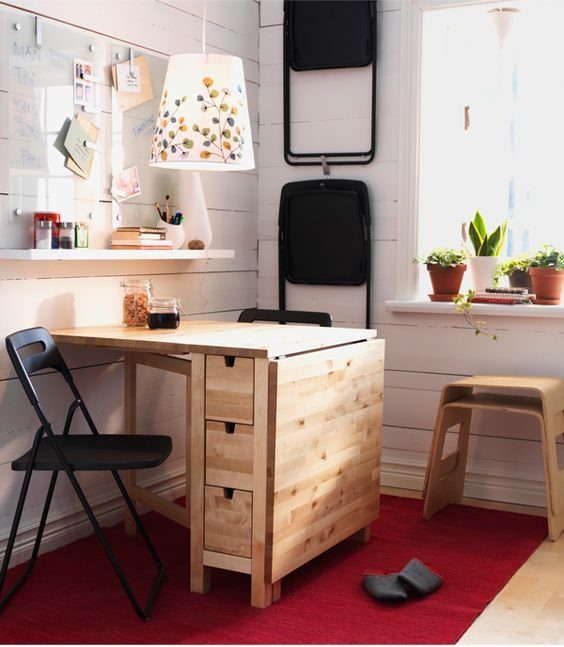 Wooden NORDEN gateleg table with drawers in a bright home office with red rug.