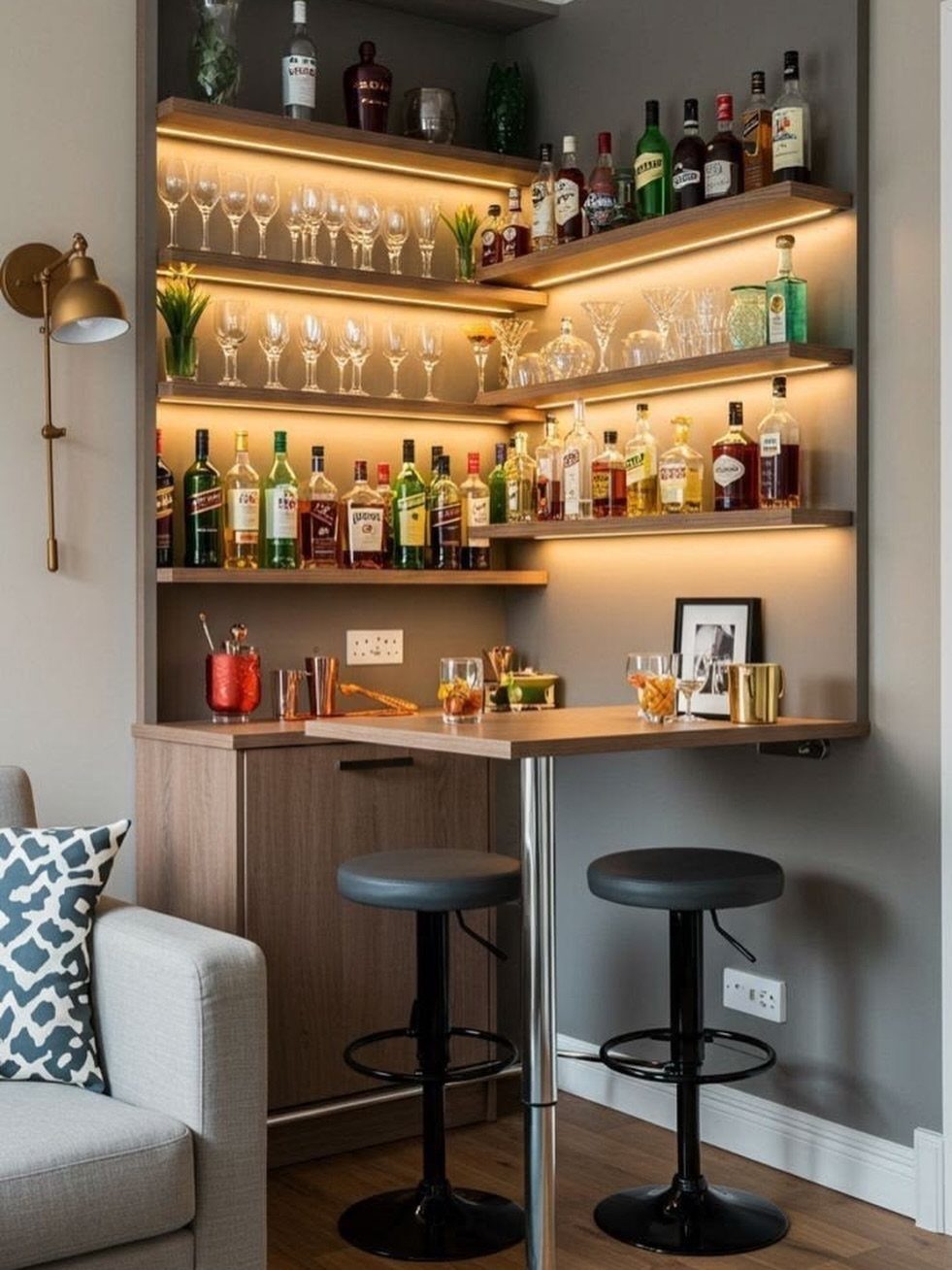 Compact modern home bar with backlit wooden shelves, liquor bottles, and black stools.