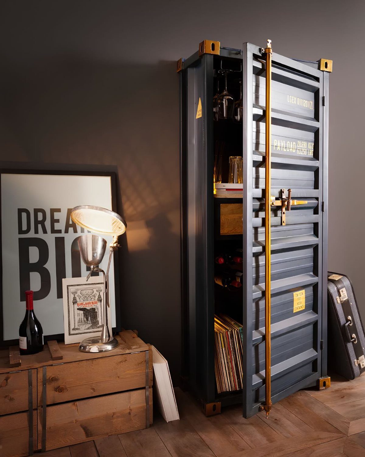 Shipping container bar cabinet with shelves for bottles and records in a room.