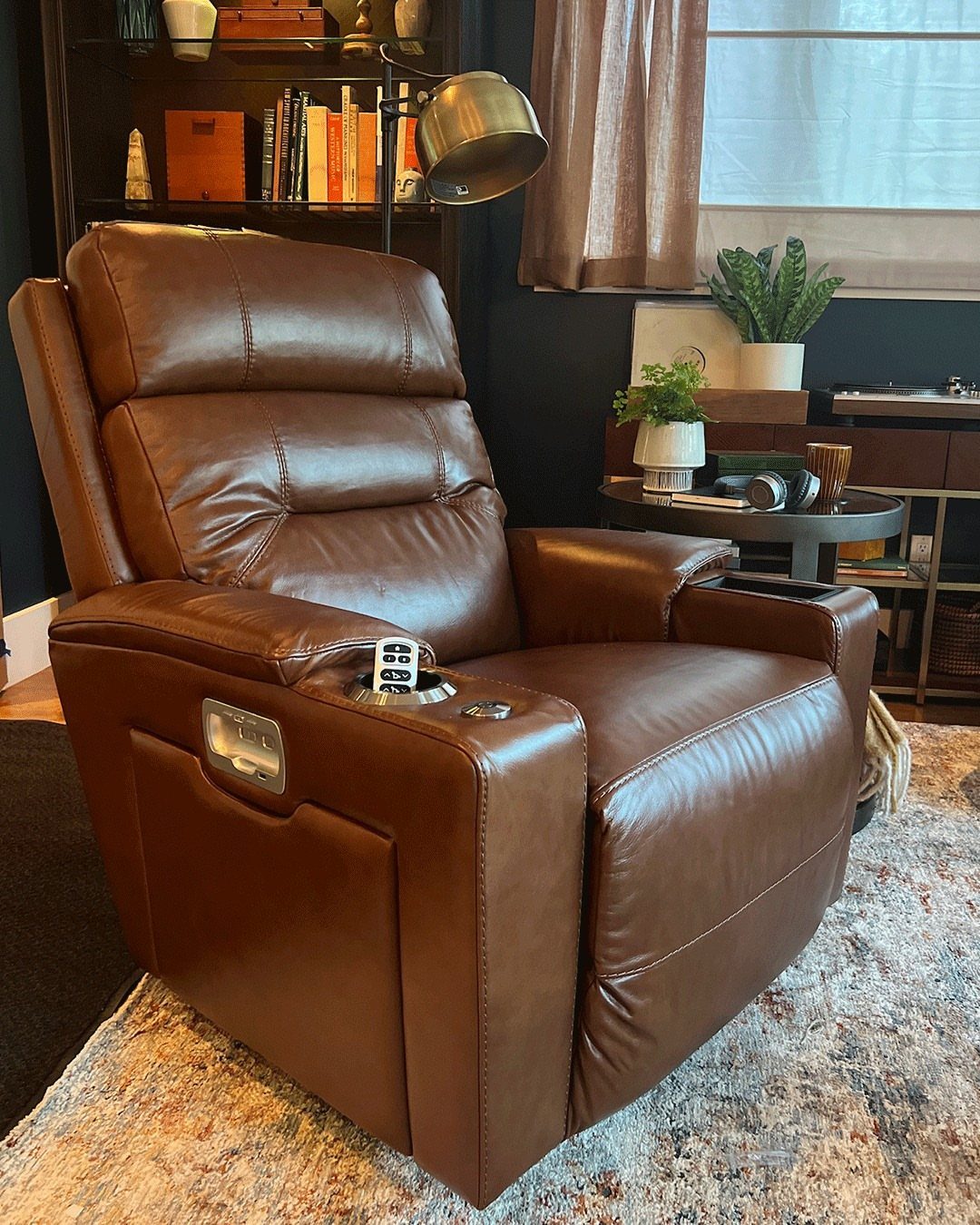 Brown leather recliner with built-in cup holder in a cozy living room setting