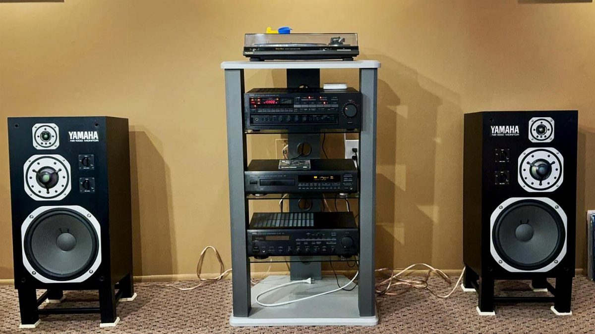 Yamaha floor-standing speakers and a multi-tier equipment rack with a turntable and amplifier.