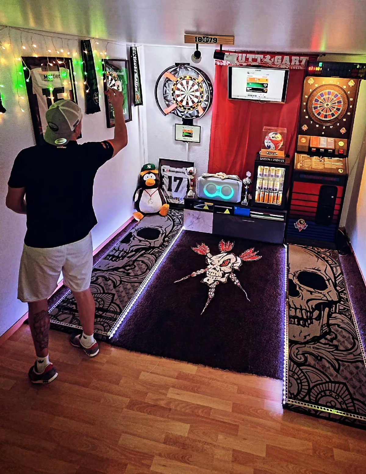 Man throwing a dart at a dartboard in a themed man cave room.
